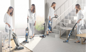 Woman using a cordless vacuum cleaner to clean throughout the home