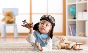 Boy with toy plane on carpet