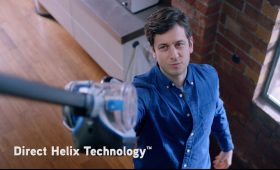 Man lifts vacuum cleaner to clean high up